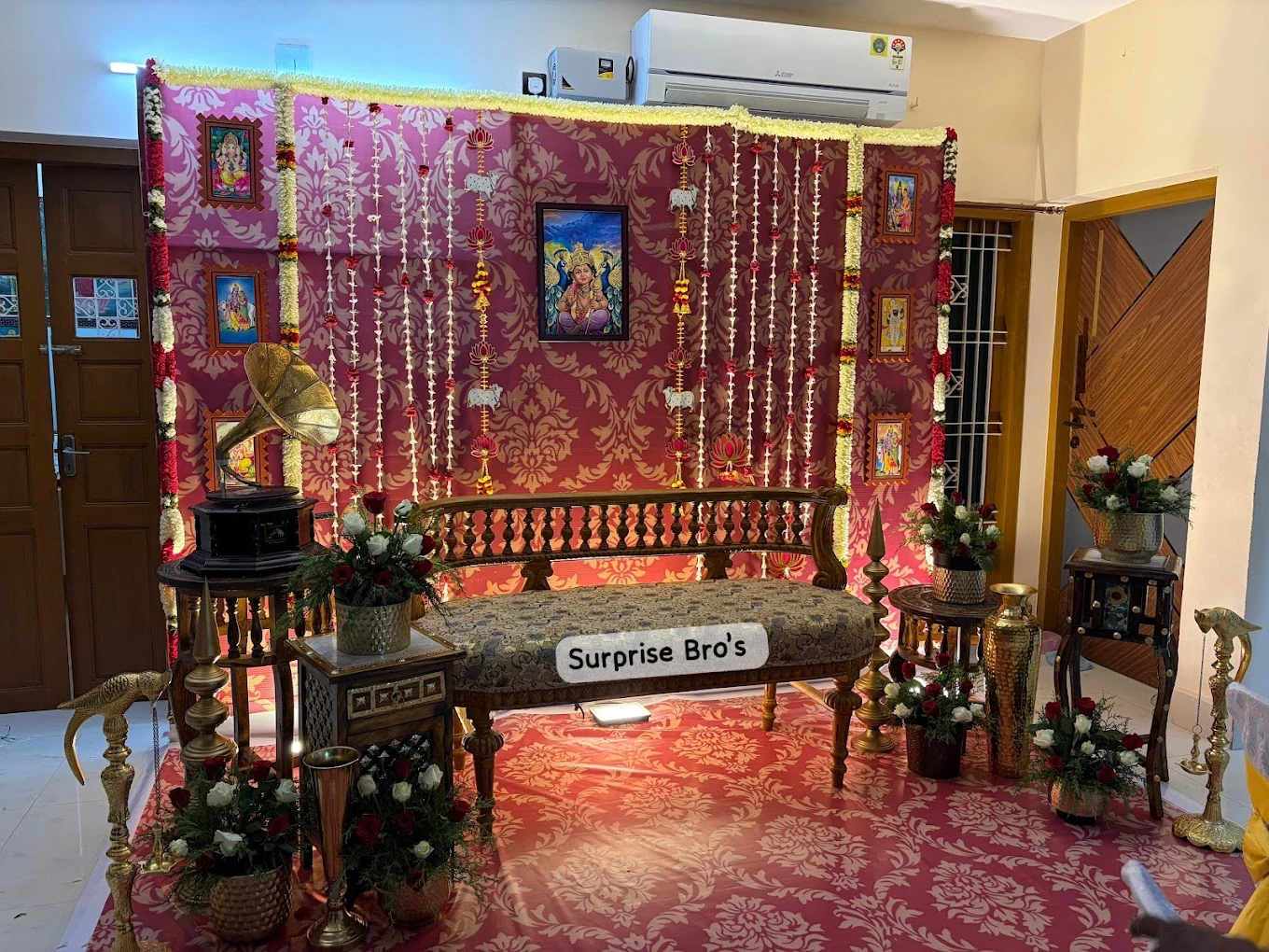 Traditional red and gold event backdrop with a carved wooden seat