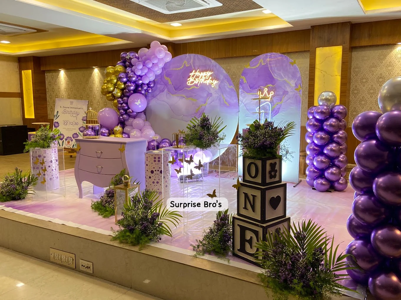 Purple and gold first birthday decor with illuminated arches