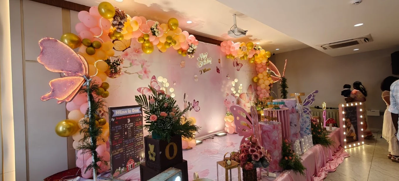 Pink and gold butterfly birthday decorations in a celebration hall