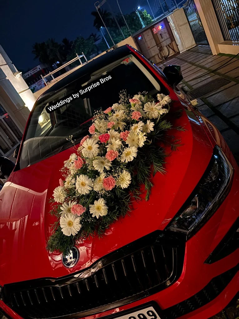 Red wedding car decorated with white and pink flowers
